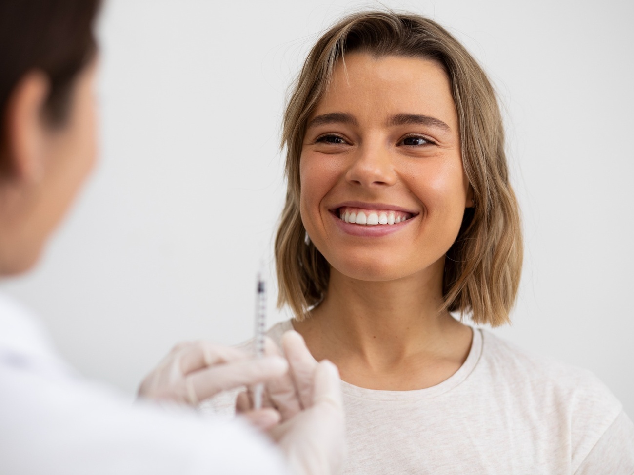 Mujer sonriendo durante una aplicación de botox