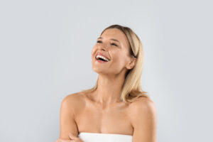 Mujer sonriendo tras un tratamiento de estética facial