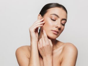 Mujer con los pómulos definidos tocándose el rostro