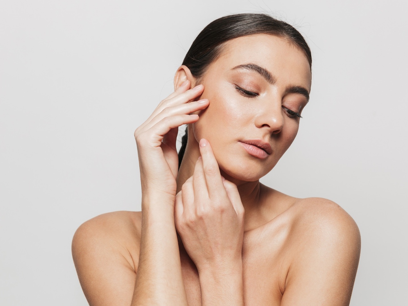 Mujer con los pómulos definidos tocándose el rostro